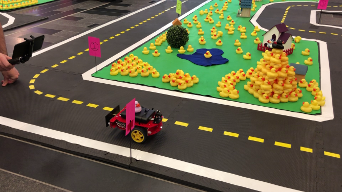 A Duckiebot travelled in Duckietown, a replication of an autonomous driving environment.