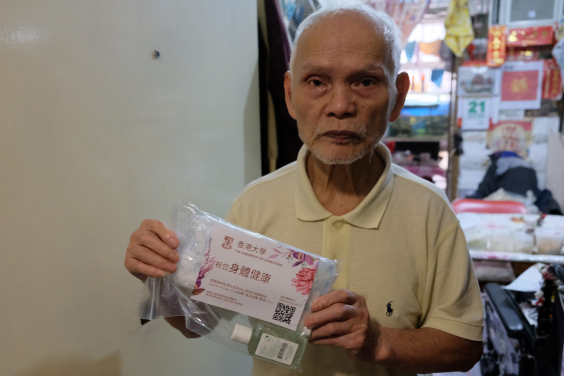 Mr Ho receives a pack of face masks from HKU 