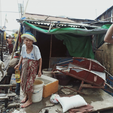 Dagon Seikkan貧民區一位老人家在家門前放置水桶，收集雨水作日常使用，瓶裝水因為昂貴，負擔不起。