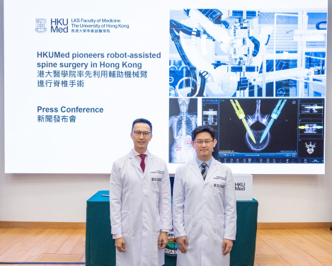 HKUMed researchers Professor Jason Cheung Pui-yin (right) and Dr Kenny Kwan Yat-hong share details of their first robot-assisted spine surgery in Hong Kong.
 